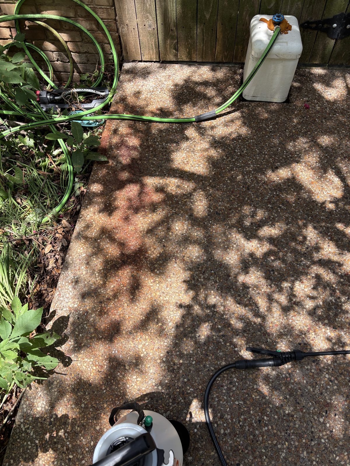 Stained aggregate concrete patio before pressure washing